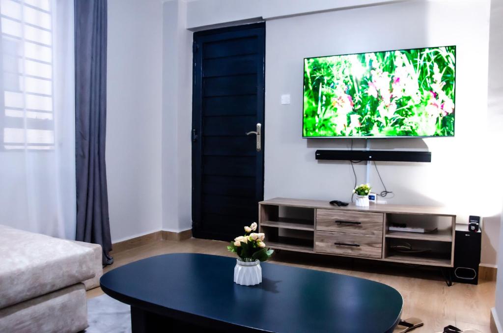 a living room with a coffee table and a flat screen tv at Keisha Homes in Thika
