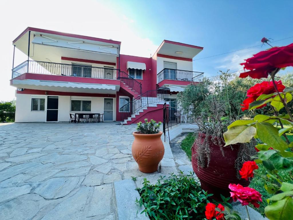 ein Haus mit einem Innenhof mit roten Blumen in der Unterkunft Villa Elia in Karianí