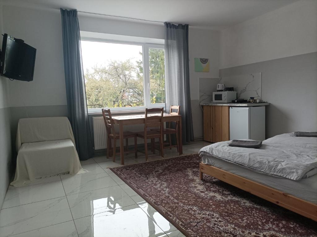1 dormitorio con cama, mesa y ventana en Za ohradami, en Závažná Poruba