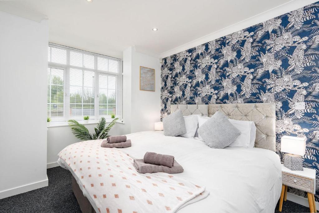 1 dormitorio con 1 cama grande y papel pintado de color azul y blanco en Delightful House with Garden, en Sherburn in Elmet