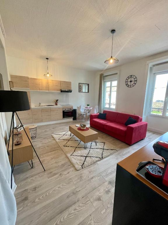 een woonkamer met een rode bank en een tafel bij Escale Confort in Montlhéry