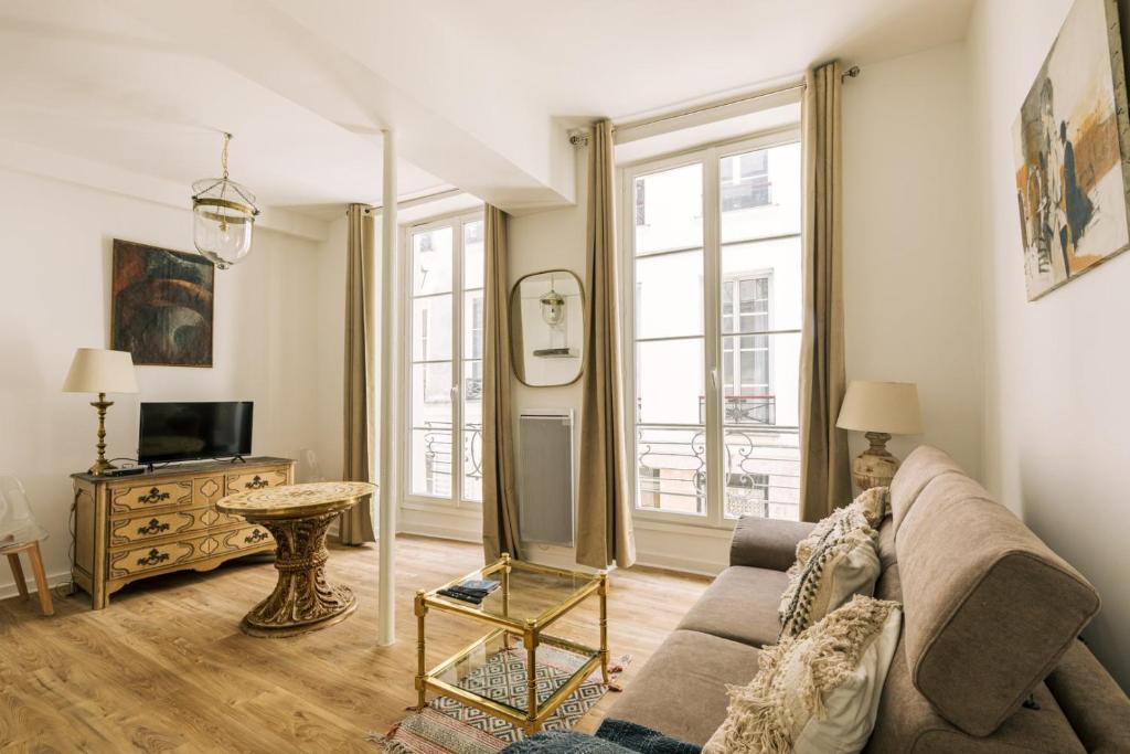 un salon avec un canapé et une télévision dans l'établissement GuestReady - Lovely studio in Paris, 15 minutes from Notre Dame Cathedral., à Paris