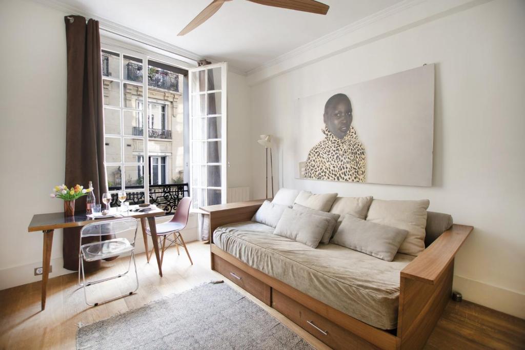 un salon avec un canapé et un bureau dans l'établissement GuestReady - Charmant studio à 10 mins du Louvre, à Paris