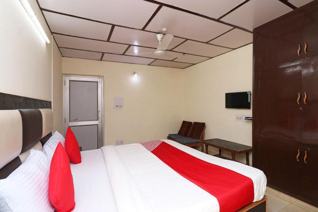 um quarto com uma cama grande e almofadas vermelhas em Hotel Country Lodge em Dharamshala