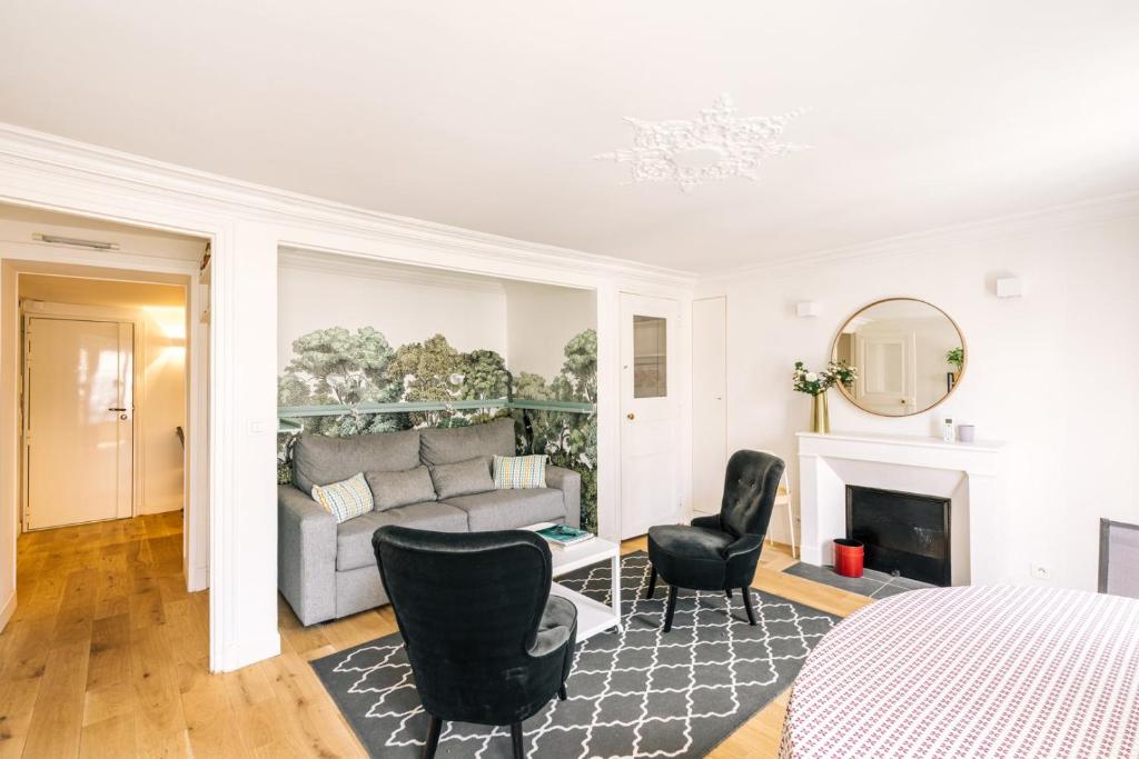 - un salon blanc avec un canapé et des chaises dans l'établissement GuestReady - Incroyable Apt Paris pour 2 dans 7arr, à Paris