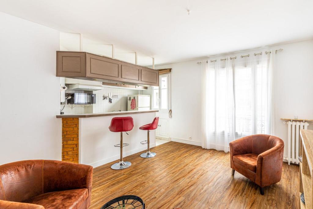 Il comprend un salon avec deux chaises et une cuisine. dans l'établissement GuestReady -Superbe Appartement dans le 14ème Arr., à Paris