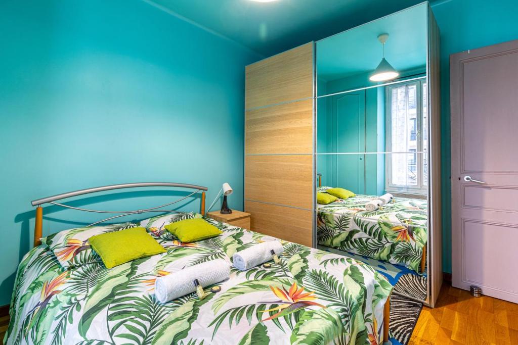 una camera da letto con pareti blu e un letto con cuscini gialli di GuestReady - Memorable stay in the suburbs a Issy-les-Moulineaux