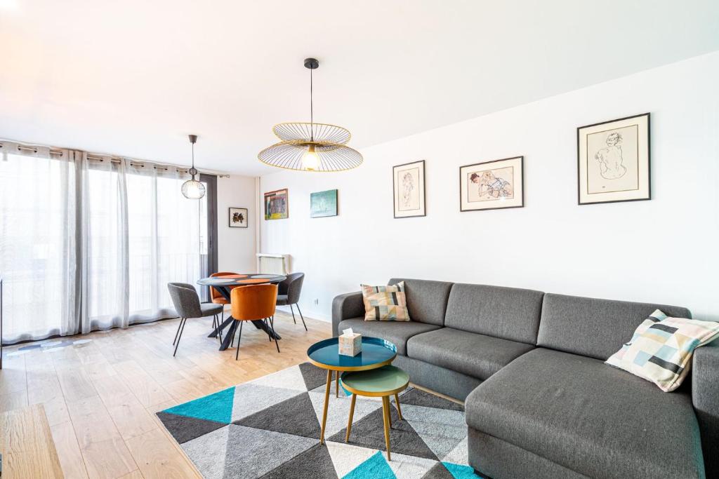 un salon avec un canapé et une table dans l'établissement GuestReady - Appartement baigné de lumière, à Paris
