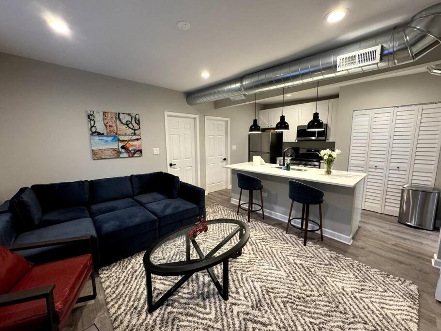 uma sala de estar com um sofá azul e uma cozinha em West Loop King Oasis/2BR that sleeps 6 guests/walk to Fulton Market em Chicago