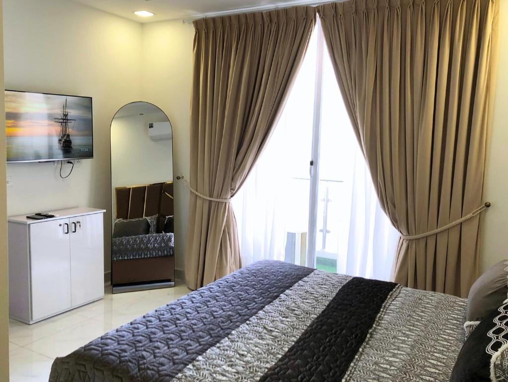 1,2 & 3 BHK Luxury Apartments at Zameen Opal في لاهور: غرفة نوم بسرير ونافذة كبيرة