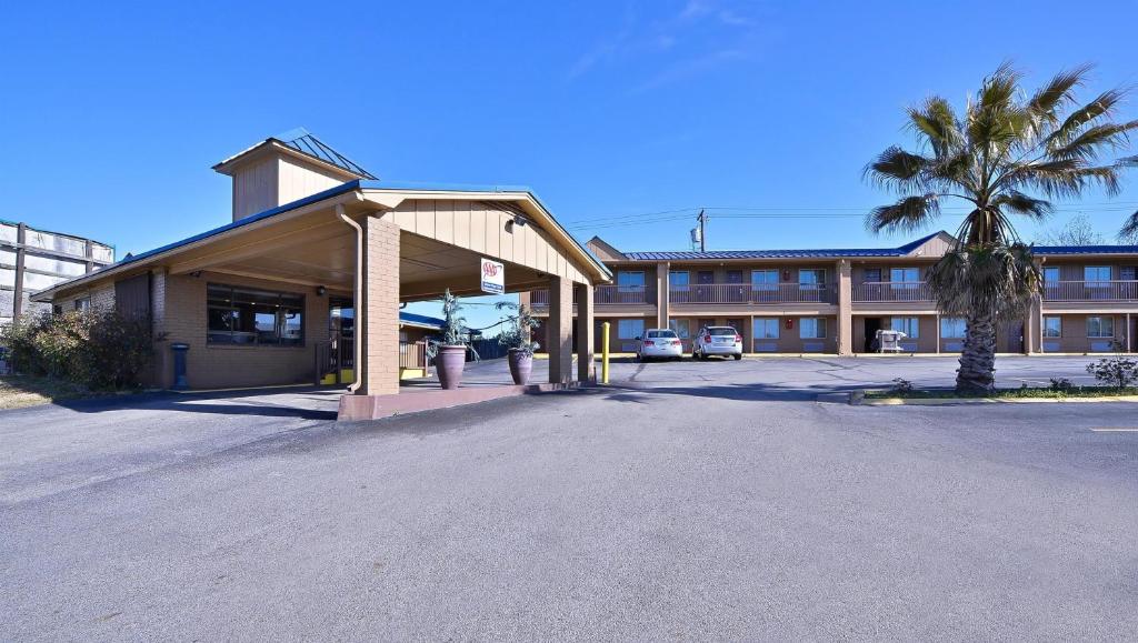 a large building with a palm tree in front of it at Xecutive Inn and Suites in Center