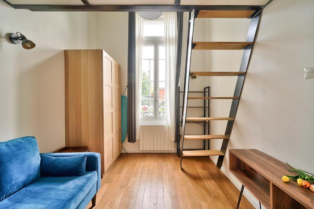 a living room with a blue couch and a spiral staircase at GuestReady - Beautiful Apt near Paris Zoo in Paris