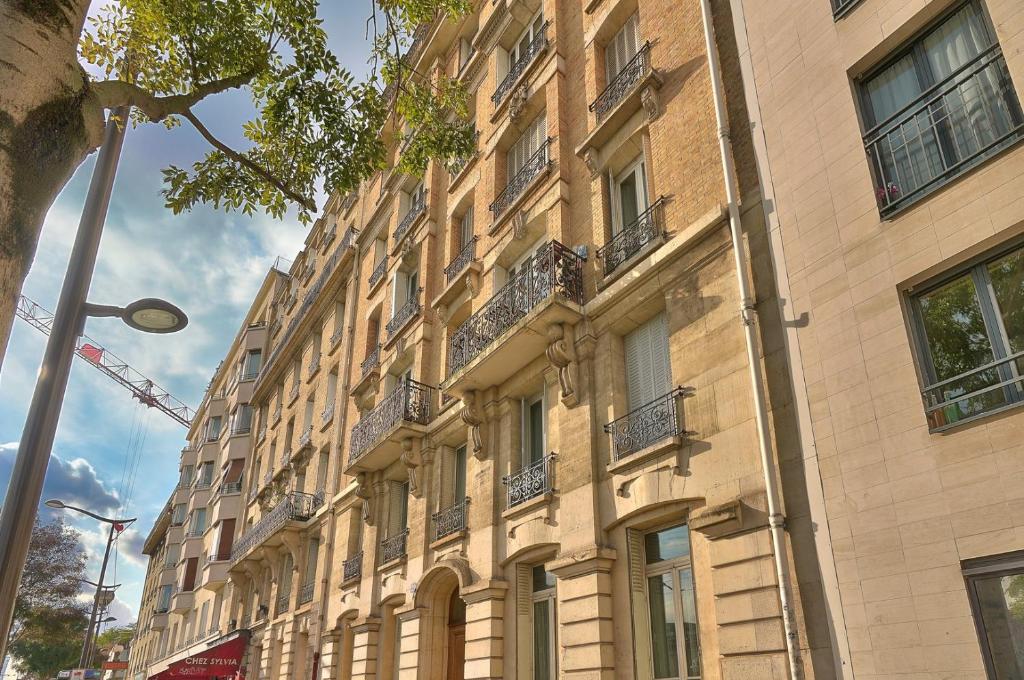 a large brick building with balconies on a street at GuestReady - Beautiful Apt near Paris Zoo in Paris