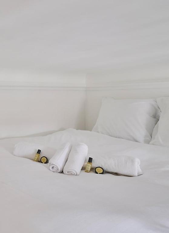 a white bed with towels and pillows on it at GuestReady - Beautiful Apt near Paris Zoo in Paris