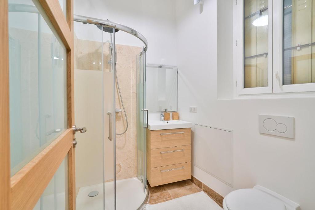 a bathroom with a shower and a toilet and a sink at GuestReady - Beautiful Apt near Paris Zoo in Paris