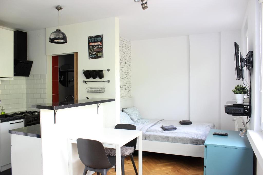a small kitchen with a small table and a bed at Labo Apartment Karmelicka in Warsaw