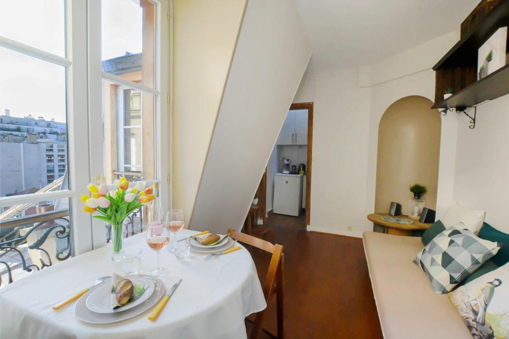 une salle à manger avec une table avec un vase de fleurs dans l'établissement GuestReady - Apt lumineux près de la gare Ranelagh, à Paris