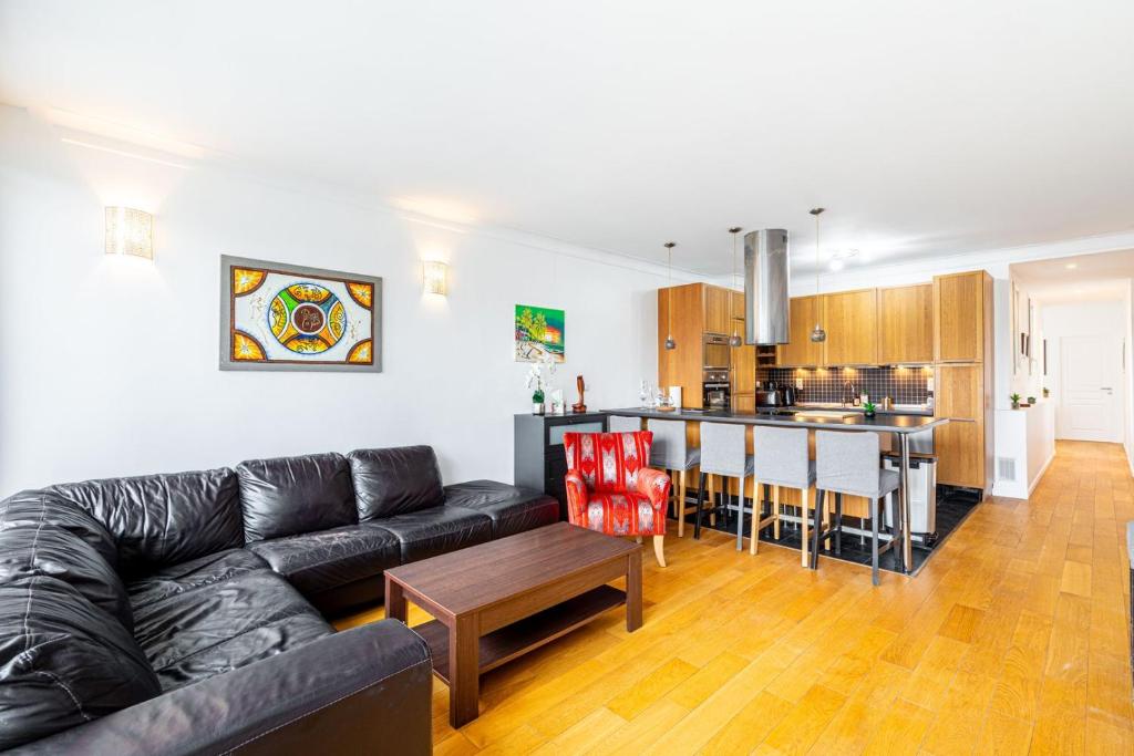a living room with a couch and a kitchen at GuestReady - Comfort near Parc Clichy-Batignolles in Paris