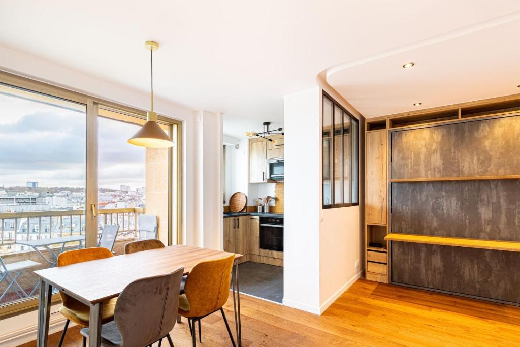 une cuisine et une salle à manger avec une table et des chaises dans l'établissement GuestReady - Studio Chic avec Vue Panoramique, à Paris