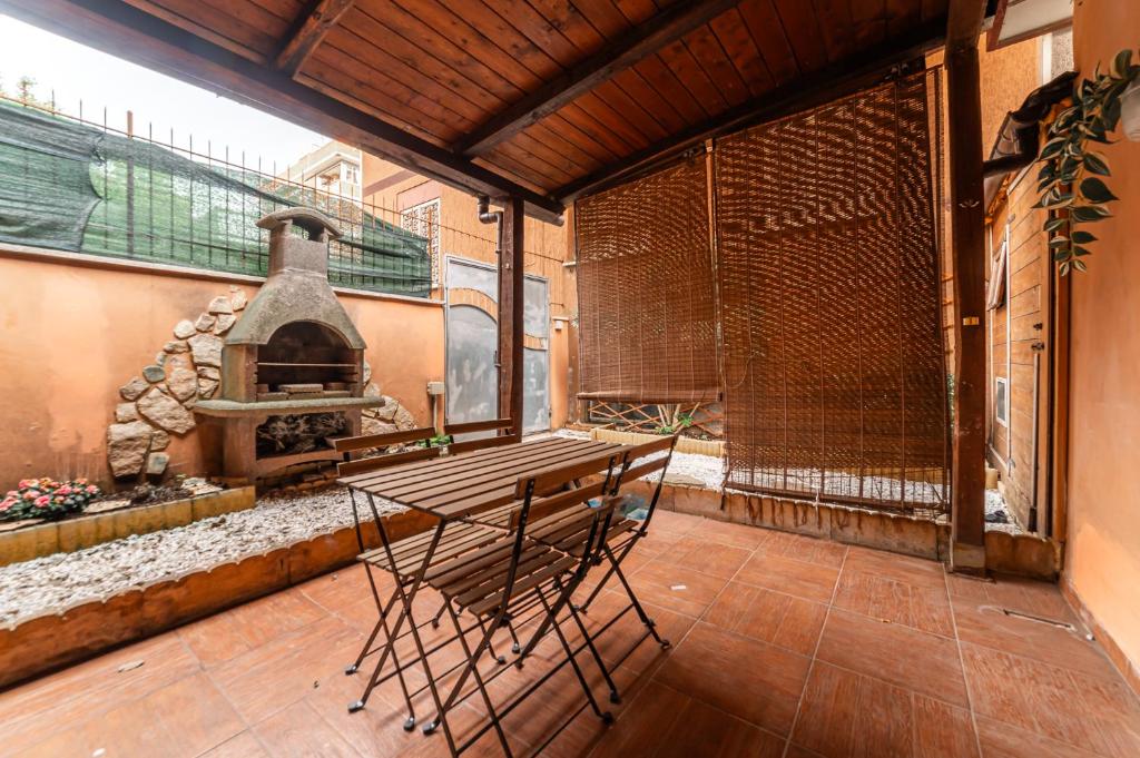 a patio with a table and an outdoor oven at Casa Sincera - Policlinico Gemelli - Metro Battistini in Rome