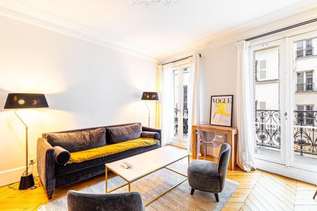 - un salon avec un canapé et des chaises dans l'établissement GuestReady - Bright stay near Jardin du Luxembourg, à Paris