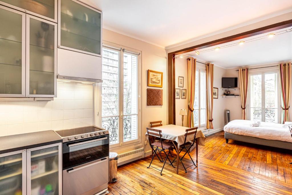 une cuisine et une chambre avec un lit dans une pièce dans l'établissement GuestReady - Charmant Appartement Lumineux, à Paris