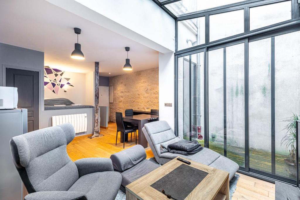 un salon avec un canapé, des chaises et une table dans l'établissement GuestReady - Studio design et fonctionnel, à Paris