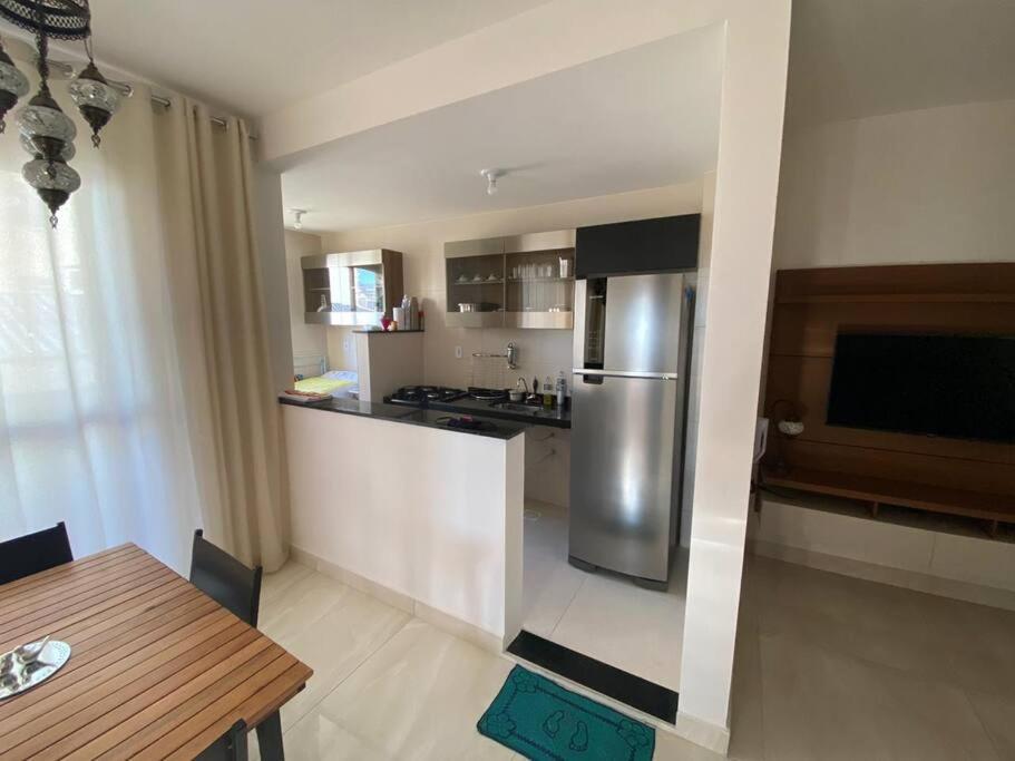 a kitchen with a stainless steel refrigerator and a table at Lindo Apto Grande e Novíssimo no Centro in Juiz de Fora