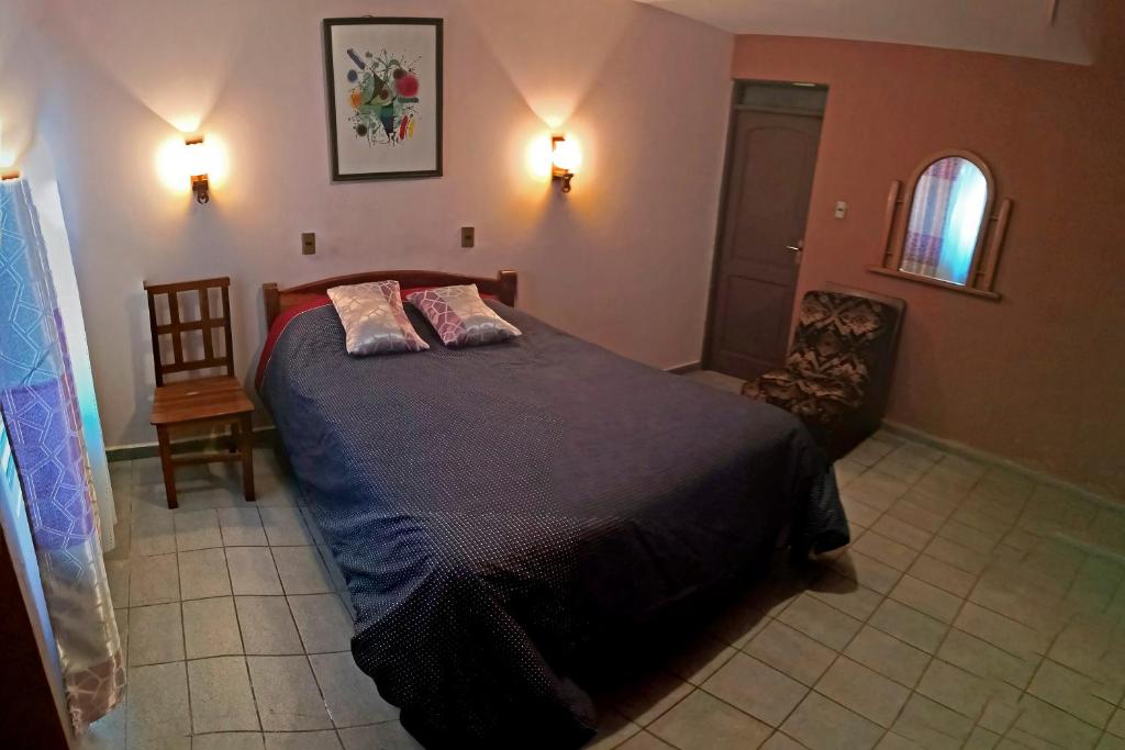 1 dormitorio con 1 cama con 2 almohadas en La Casa Discreta Cochabamba, en Cochabamba