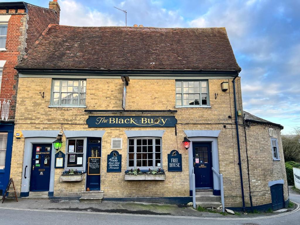 un edificio de ladrillo con puertas y ventanas azules en Black Buoy Inn, en Wivenhoe