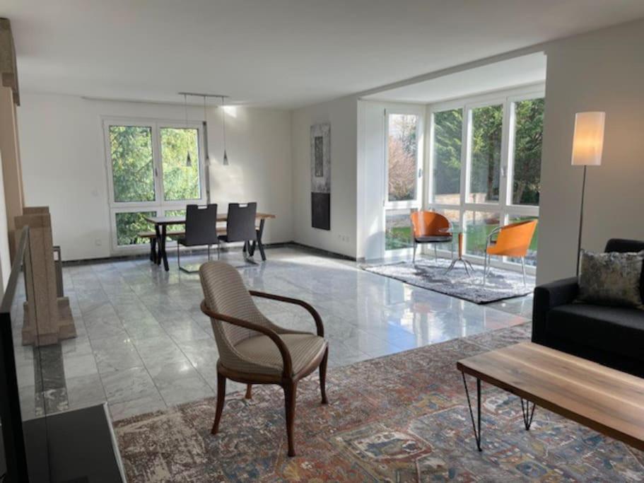 uma sala de estar com cadeiras, um sofá e uma mesa em Amazing 2 bedroom flat: specious and central (Duke2) em Zurique