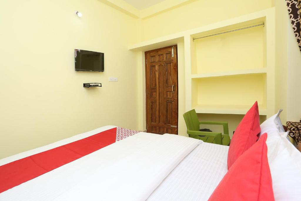 um quarto com uma cama e uma televisão na parede em Flagship Nandan Residency em Bārang