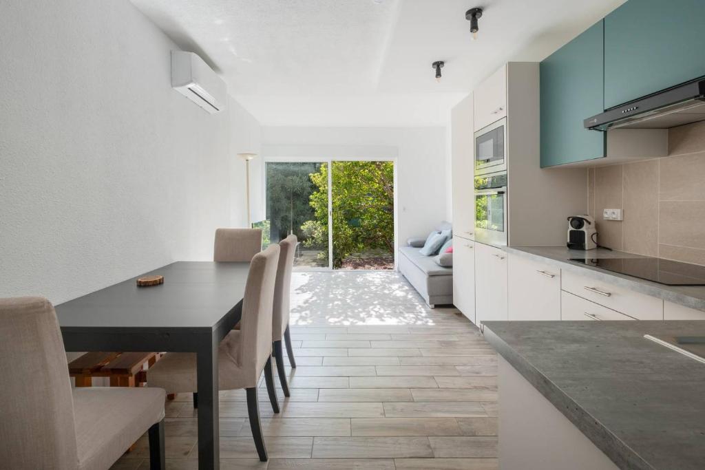 une cuisine et une salle à manger avec une table et des chaises dans l'établissement AS24411 - Studio cabine + chalet avec jardin et parking, au Grau-du-Roi