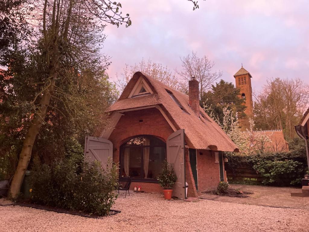 una piccola casa con tetto marrone di Cottage Guest House in Wassenaar a Wassenaar