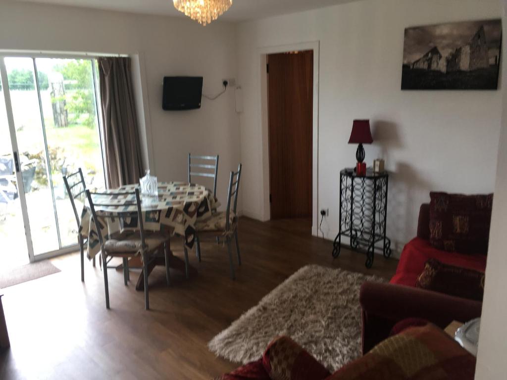 a living room with a dining room table and chairs at Ruthven House Holiday Cottages in Kingussie