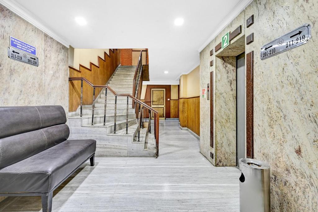 een trap in een gebouw met een bank en een trap bij Townhouse OAK Hotel Belsons Taj Mahal in Secunderābād