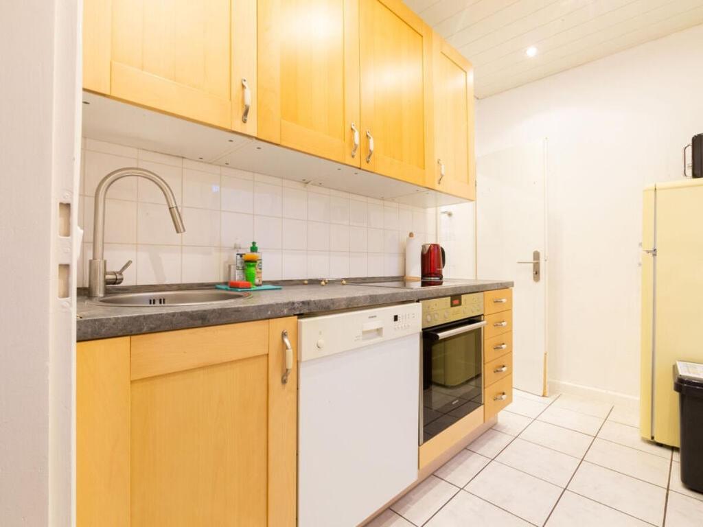 uma cozinha com armários de madeira e um lavatório em Alstaden 2 Modern retreat em Oberhausen