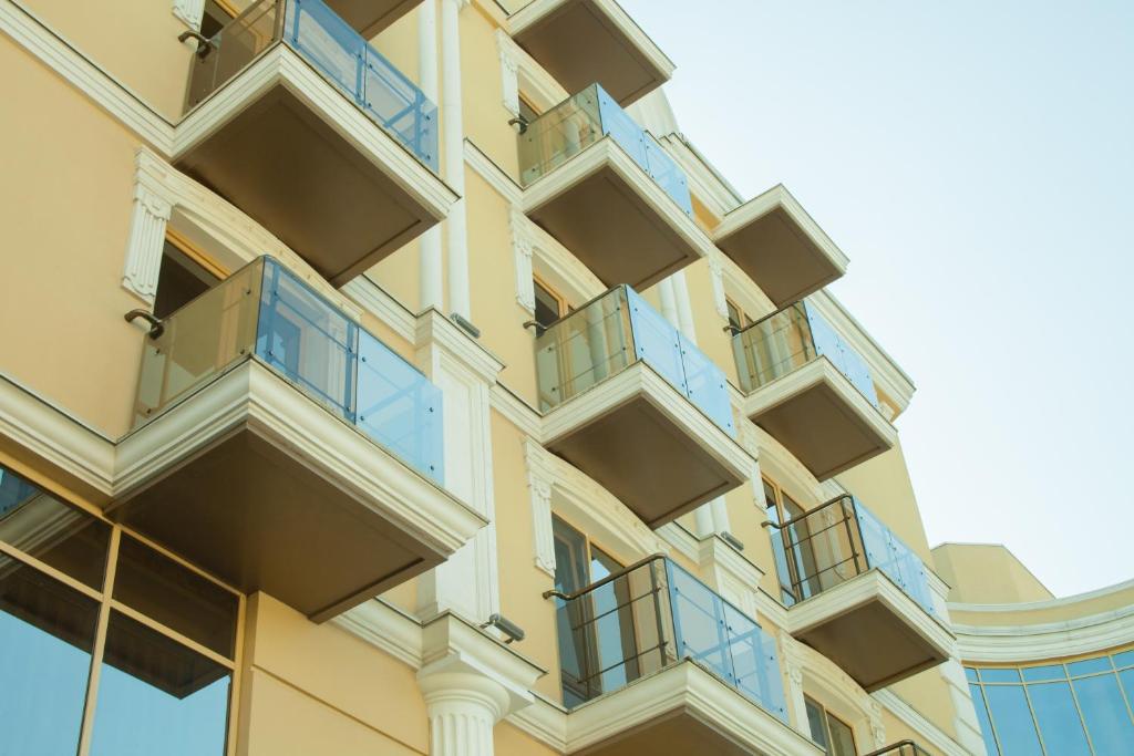 un edificio de apartamentos con balcones azules en GRAND OTRADA Hotel Resort & SPA en Odesa