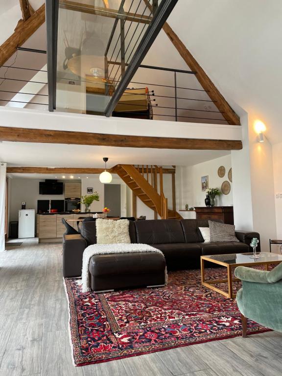 - un salon avec un canapé noir et un tapis dans l'établissement l'héberge des Argales, à Vred