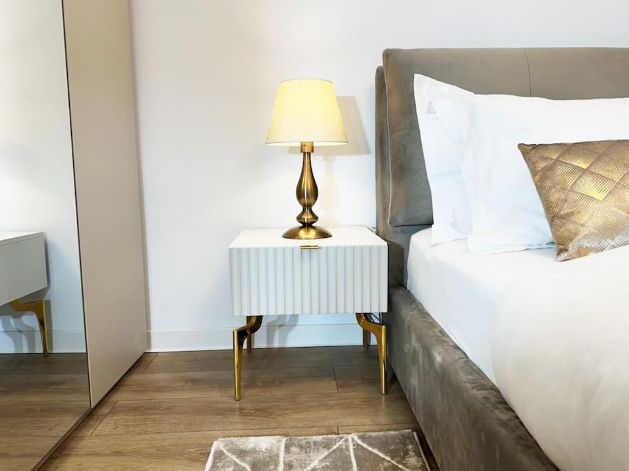 un letto con un tavolino e una lampada sopra di Uno Blue Residence a Braşov