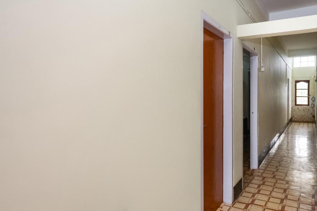 pusty korytarz z podłogą wyłożoną kafelkami i białymi ścianami w obiekcie SPOT ON 37875 Hotel Kirtti Inn w mieście Soalkuchi