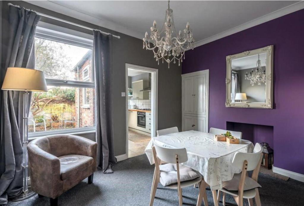 une salle à manger avec des murs violets, une table et des chaises dans l'établissement Entire 2-bedroom house with garden, à York
