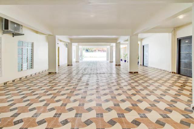 een lege kamer met een geruite vloer in een gebouw bij MN Stays in Vijayawāda