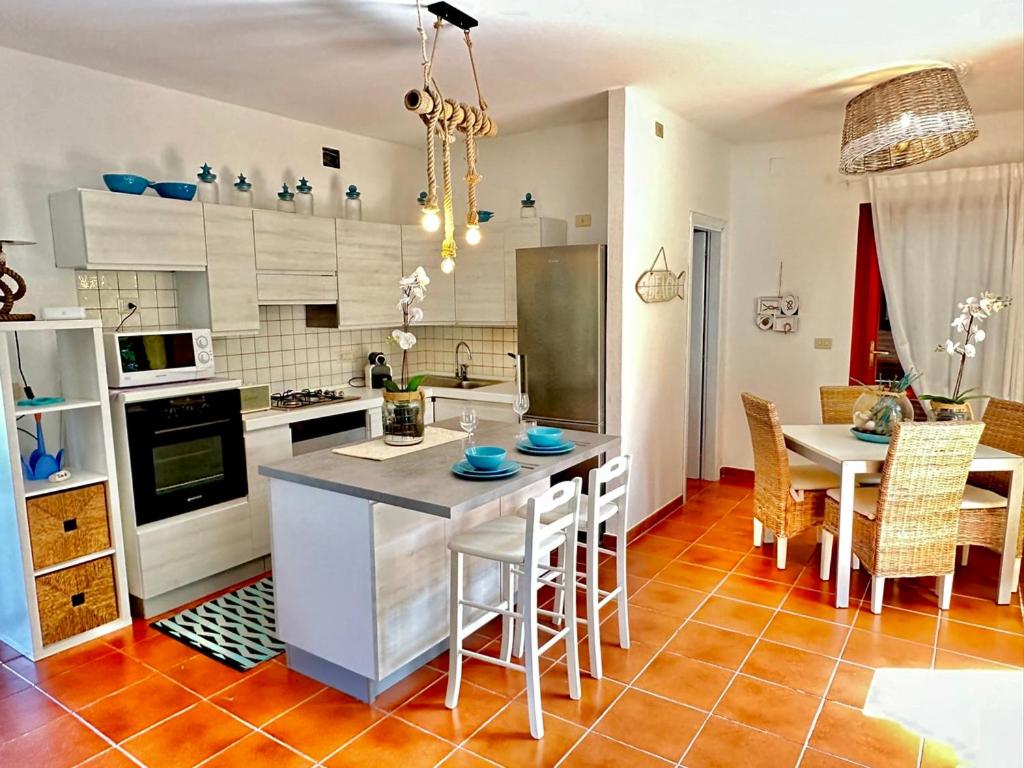 a kitchen with a table and chairs in a room at Casa Alba in Stintino