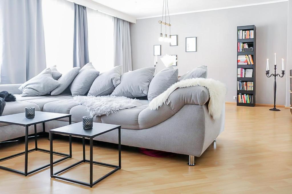 ein weißes Wohnzimmer mit einem Sofa und 2 Tischen in der Unterkunft CityCharme-Apartment in Braunschweig