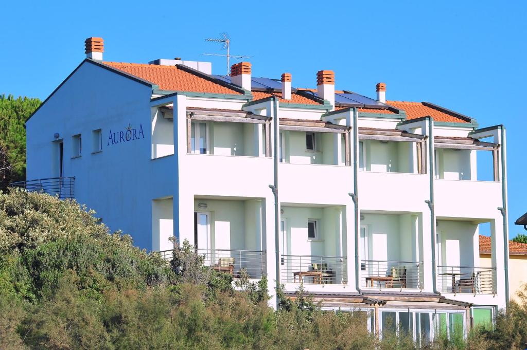 a white building with a red roof at Hotel Aurora in San Vincenzo
