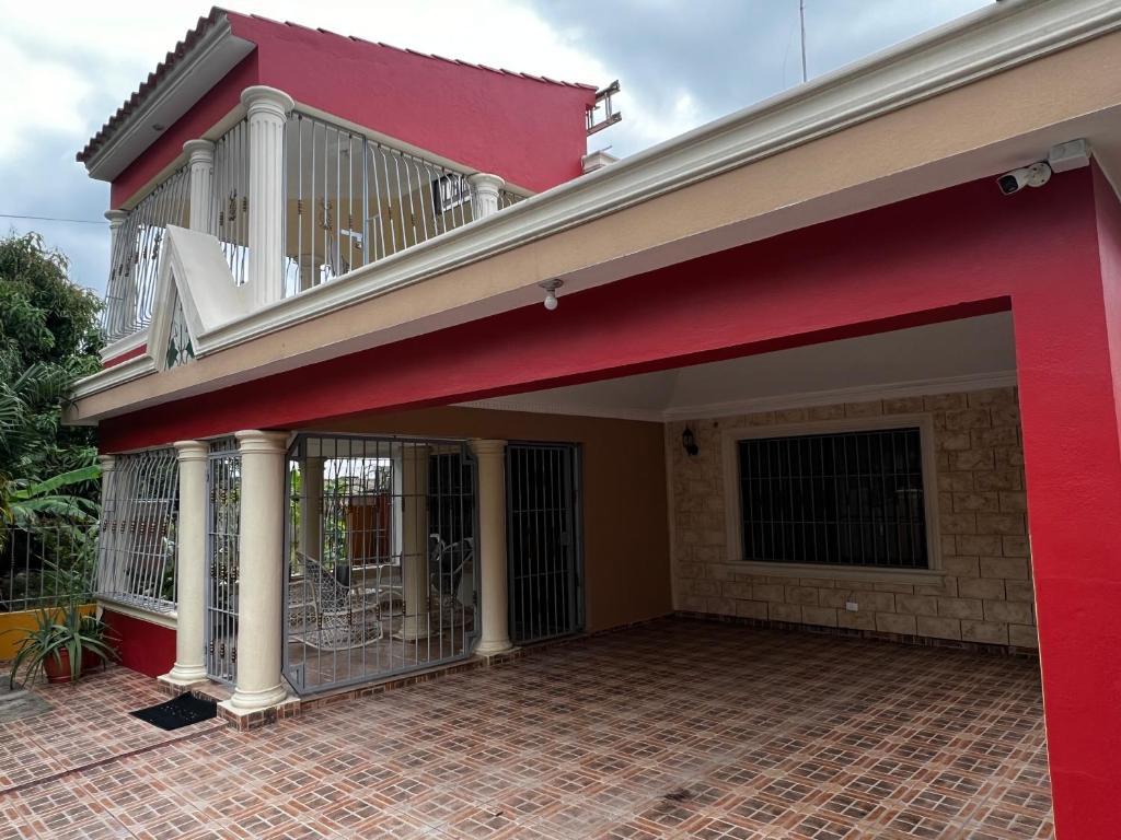 a red house with a balcony on top of it at Casa Deisy in Santiago de los Caballeros