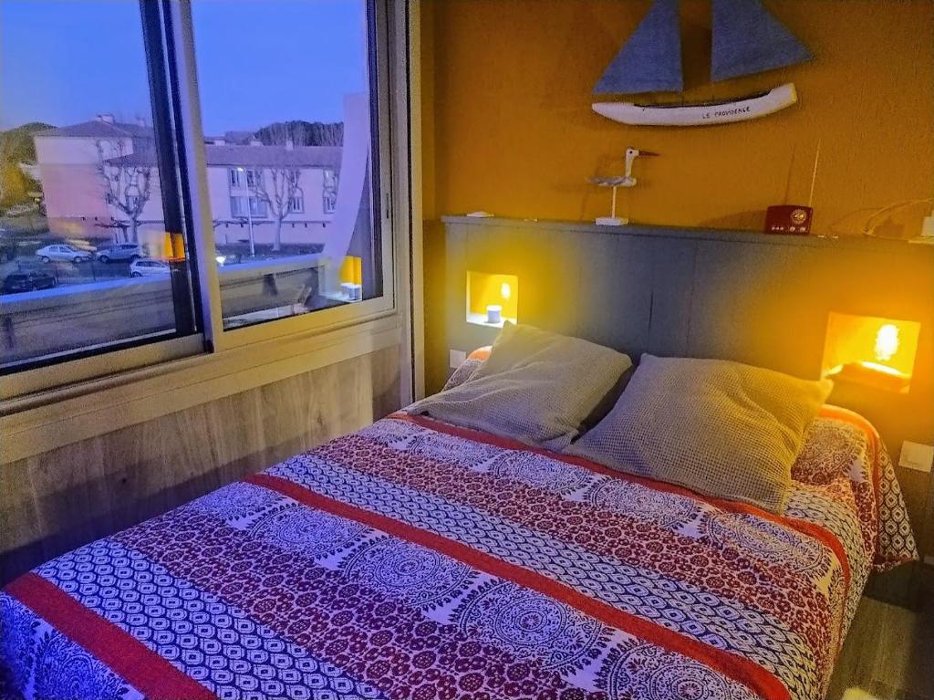 a bedroom with a bed and a window with a view at ALAMANDA STUDIO LE GRAU DU ROI - in Le Grau-du-Roi