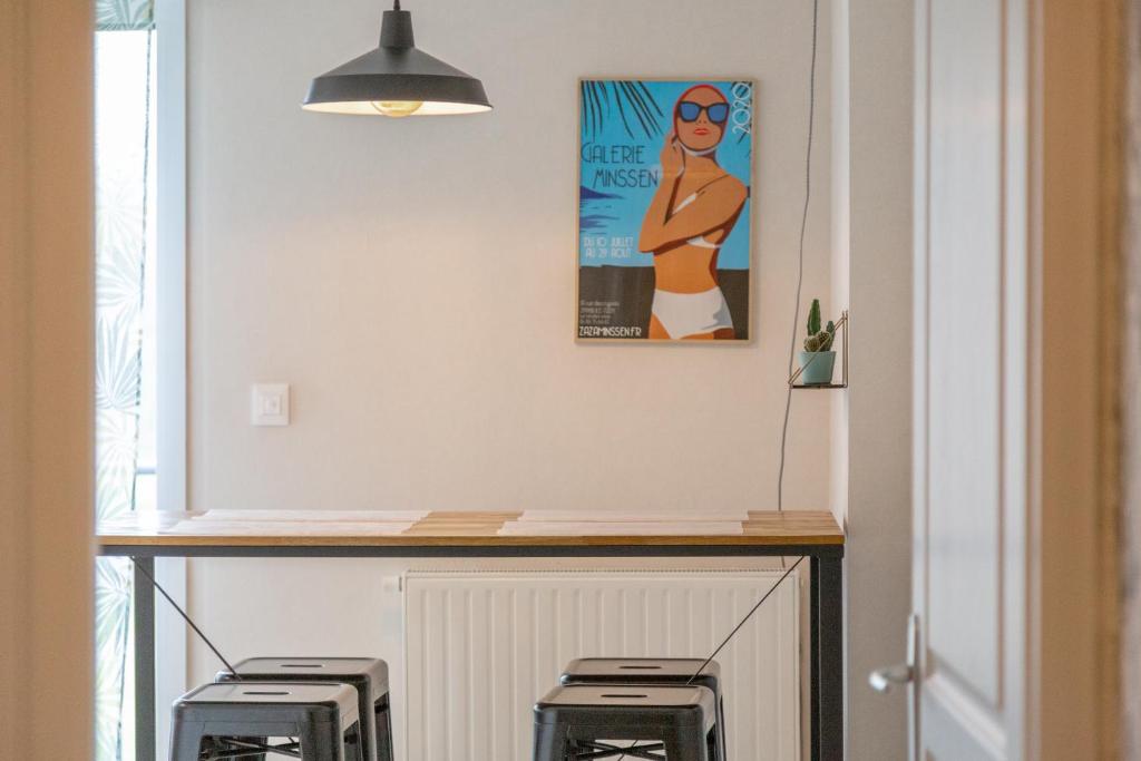 a kitchen with a counter with three stools under it at Appartement vue mer - 200m plage in Concarneau