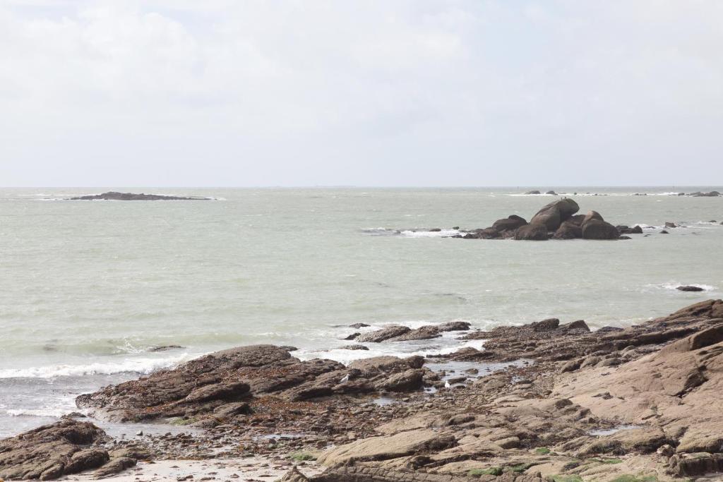 a beach with some rocks in the water at Appartement vue mer - 200m plage in Concarneau